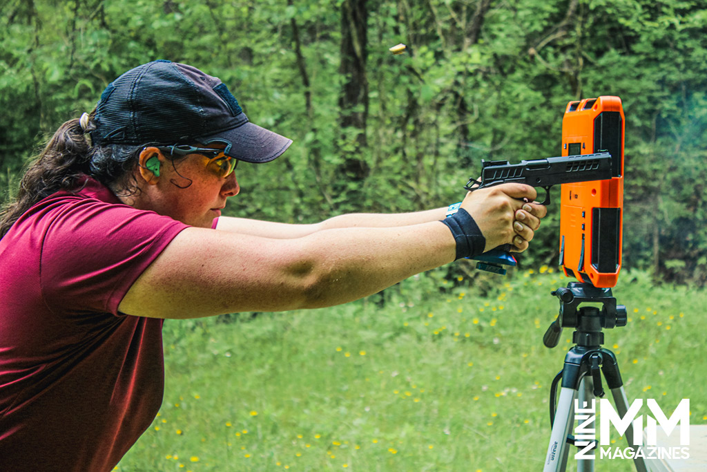 a photo of a female competition shooter using a chronograph