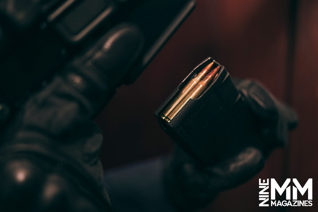 a photo of a man loading a magazine into a ar15 rifle