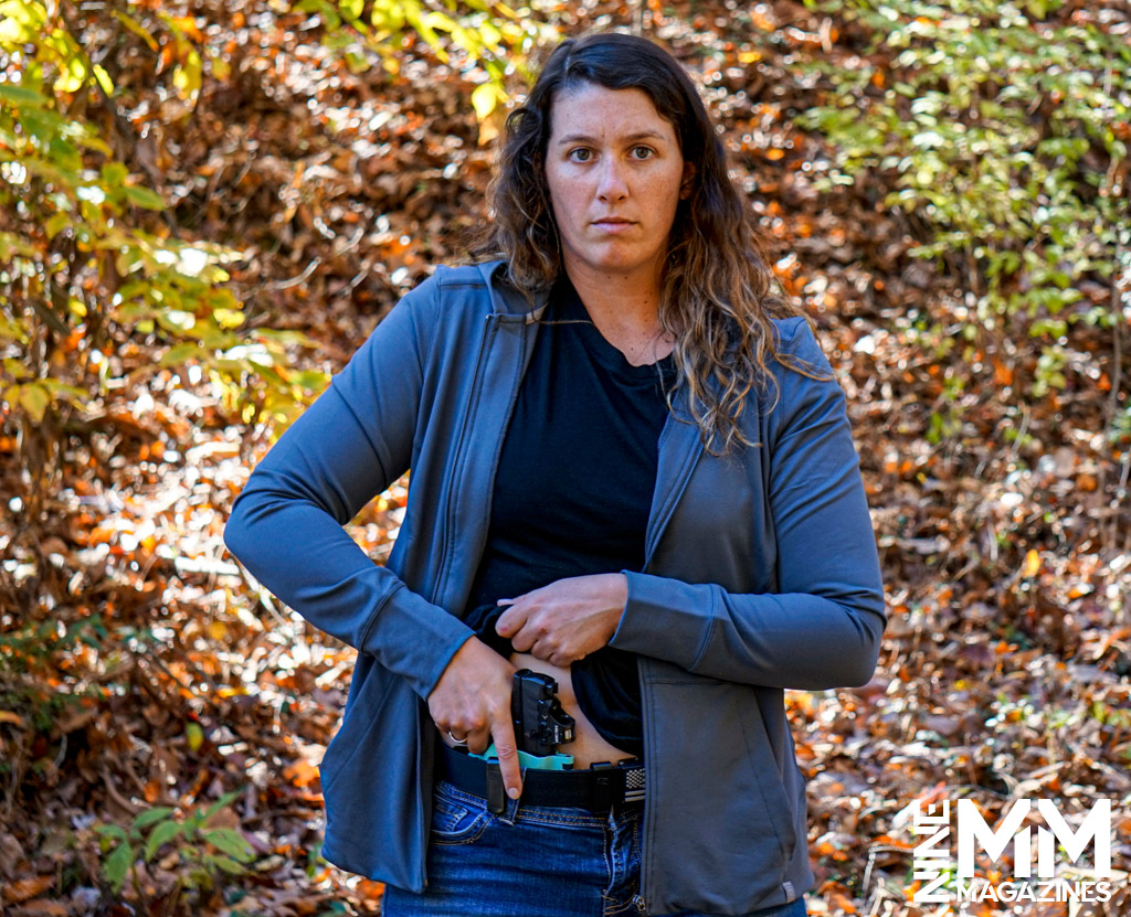 a photo of a woman drawing a handgun