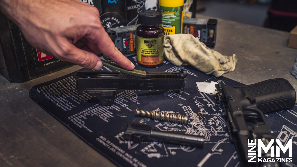 a photo of a man cleaning a glock handgun