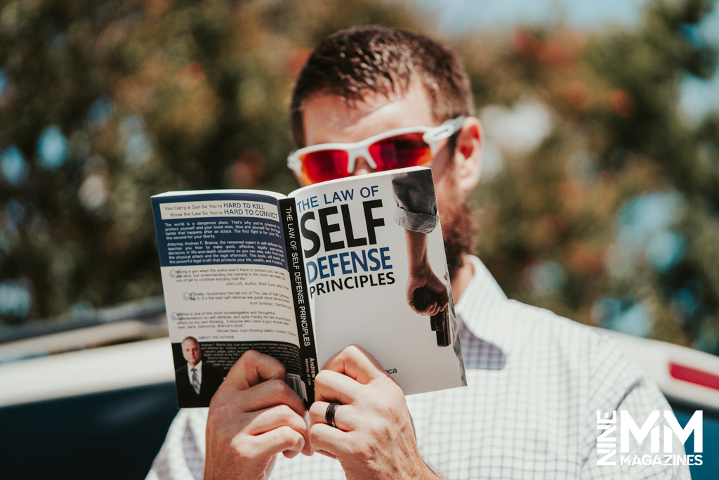 a photo of a man reading a book outdoors