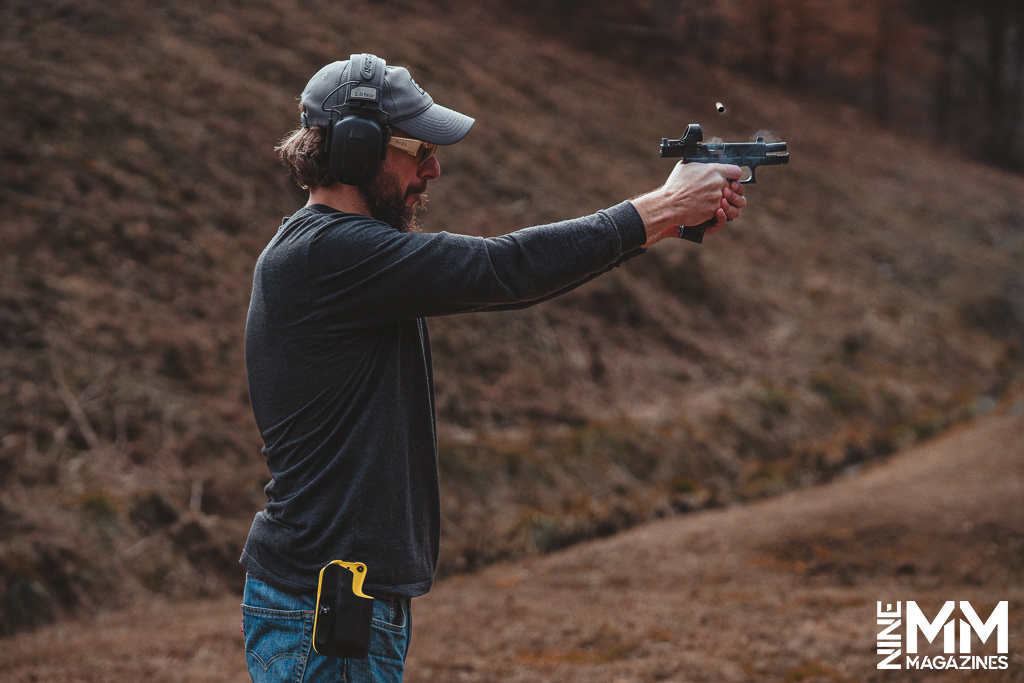 a photo of a man shooting a glock with a red dot optic