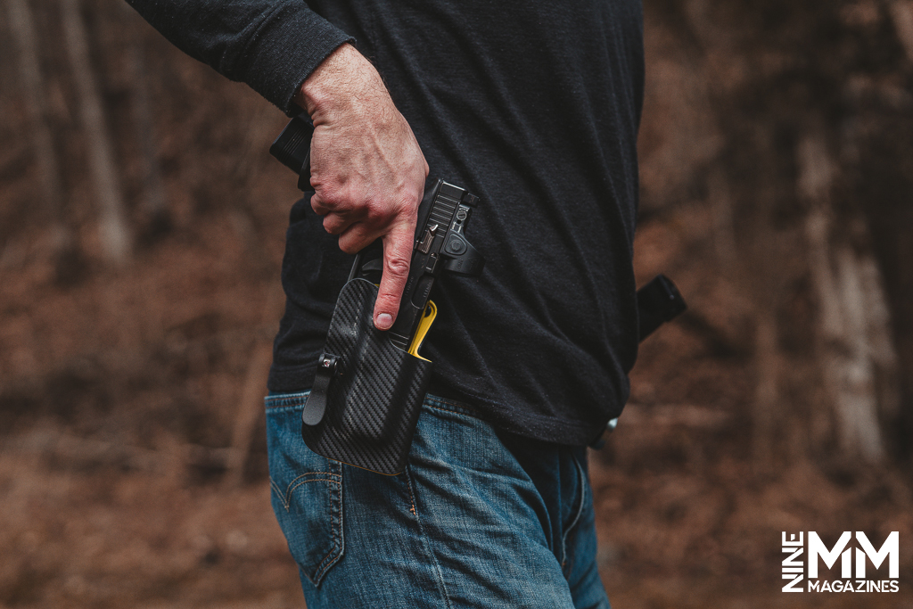 a photo of a man drawing a gun from a holster