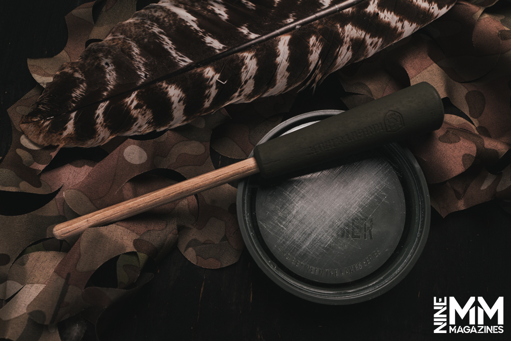 a photo of a turkey call and turkey feather 