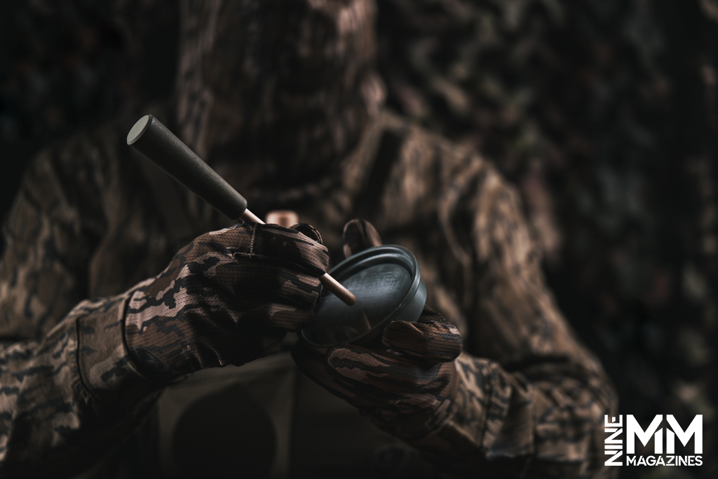 a photo of a hunter using a turkey call