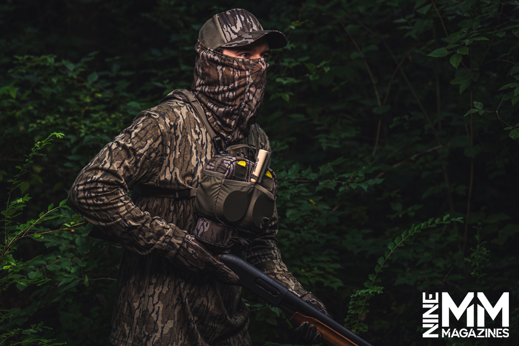 a photo of a hunter with a shotgun in the woods