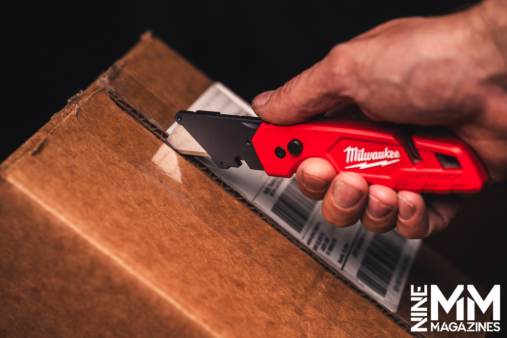 a photo of a man using a box cutter knife